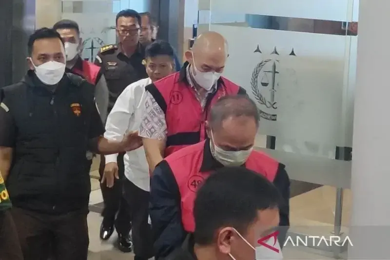 Petugas pada Kejaksaan Agung menggiring beberapa tersangka baru dalam kasus korupsi importasi gula di Kementerian Perdagangan pada tahun 2015–2016, menuju mobil tahanan di Gedung Kejaksaan Agung, Jakarta, Senin (20/1/2025). ANTARA/Nadia Putri Rahmani.