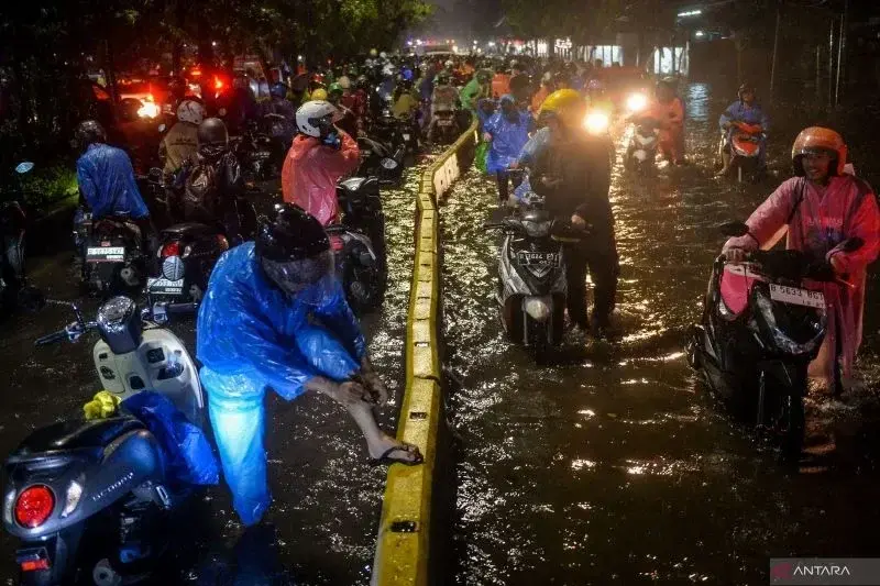 Sejumlah pengendara motor menuntun motornya melewati banjir di Jalan Daan Mogot, Cengkareng, Jakarta, Selasa (28/1/2025). ANTARA FOTO/Putra M. Akbar/gp/foc.