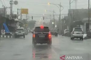 Ilustrasi - Warga mendayung sepeda saat hujan (ANTARA FOTO/Wahyu Putro)