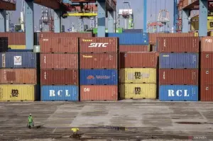 Petugas berjalan di samping peti kemas di kawasan Jakarta International Container Terminal (JICT), Tanjung Priok, Jakarta, Rabu (15/1/2025). ANTARA FOTO/Dhemas Reviyanto/agr