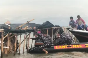 TNI AL bersama dengan masyarakat sekitar  membongkar pagar laut di kawasan Tanjung Pasir, Kabupaten Tangerang, Banten, Sabtu (18/1/2025). (ANTARA/Walda Marison)
