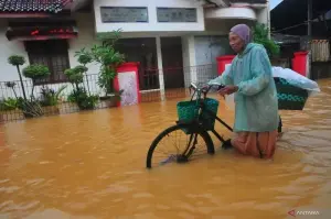 Arsip - Warga saat melintasi jalan yang tergenang banjir di Desa Mejobo Kudus Jawa Tengah, Kamis (30/1/2025). ANTARA FOTO/Yusuf Nugroho/nym.