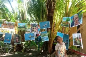 Seorang anak kecil asik melihat foto-foto yang terpajang di pohon sagu, pada Pameran fotografi yang dikemas dalam Pagelaran Seni dan Budaya sanggar Robongholo bertema Simfoni Alam dan Budaya. ANTARA/Agustina Estevani Janggo