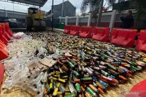 Petugas memusnahkan minuman keras hasil razia dan tindak pidana ringan (tipiring) di tempat pemusnahan barang bukti Kantor Kejaksaan Negeri Kabupaten Garut, Jawa Barat. (ANTARA/Feri Purnama)