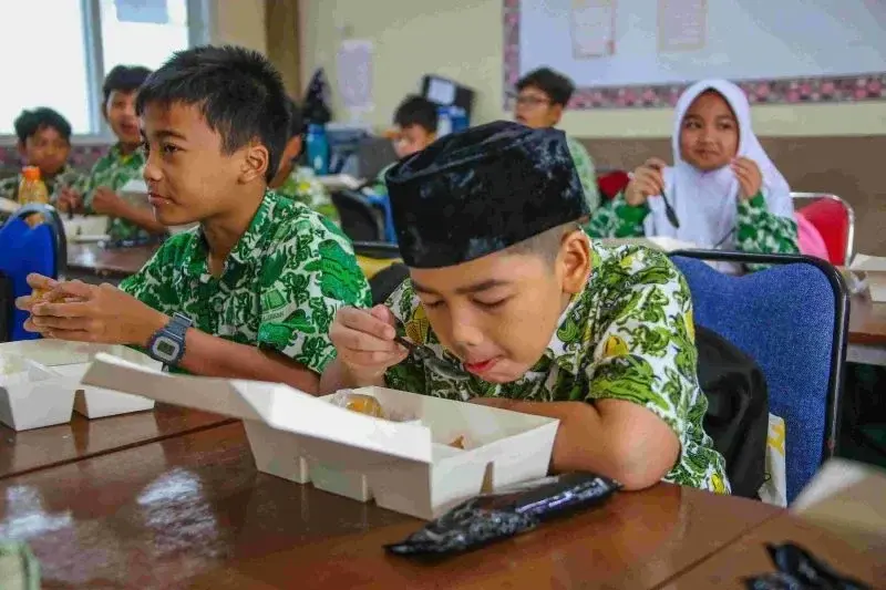 Peserta didik menyantap makanan bergizi dalam program Makanan Bergizi Gratis (MBG). ANTARA/HO-Pemprov DKI Jakarta.