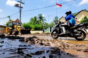 Seorang pengendara melintas di jalan berlumpur pasca-banjir bandang di Kecamatan Kendit, Kabupaten Situbondo, Jawa Timur. ANTARA/Novi Husdinariyanto