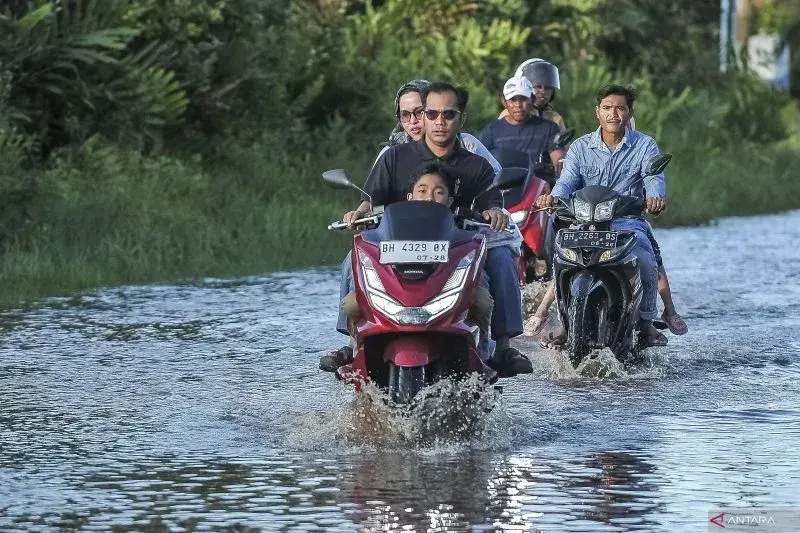 Pengendara menerobos Jalan Sri Soedewi yang terendam banjir rob di Kuala Tungkal, Tanjung Jabung Barat, Jambi, Sabtu (1/3/2025). ANTARA FOTO/Wahdi Septiawan/YU (ANTARA FOTO/WAHDI SEPTIAWAN)