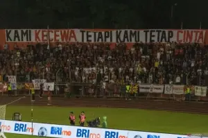 Suporter Semen Padang membentangkan spanduk dukungan kepada klub asal Ranah Minang tersebut saat laga Semen Padang berhadapan Persib Bandung di Stadion Haji Agus Salim, Kota Padang, Senin (10/3/2025). (ANTARA/Muhammad Zulfikar)
