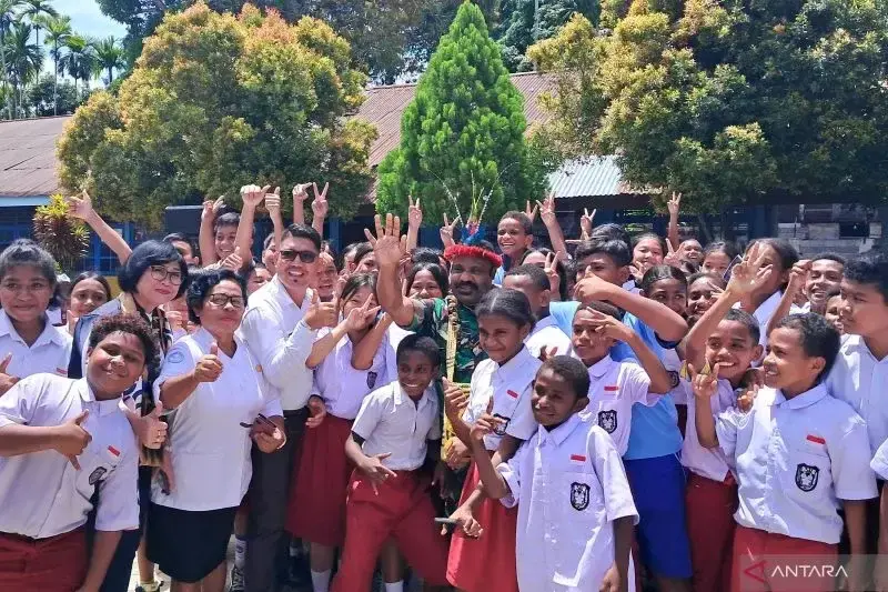 Staf Khusus Menteri Pertahanan (Menhan) Bidang Kedaulatan Negara Kesatuan Republik Indonesia Letkol Tituler Lenis Kogoya (berseragam TNI) berfoto bersama para siswa SD YPK Sion, Nabire, Papua Tengah, pada Selasa (11/3/2025) usai menyosialisasikan program Makan Bergizi Gratis (MBG). (ANTARA/Lintang Budiyanti Prameswari)