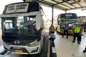Sejumlah petugas memeriksa kondisi kelayakan kondisi kendaraan angkutan umum di Terminal Guntur, Kabupaten Garut, Jawa Barat, Senin (17/3/2025). (ANTARA/Feri Purnama)