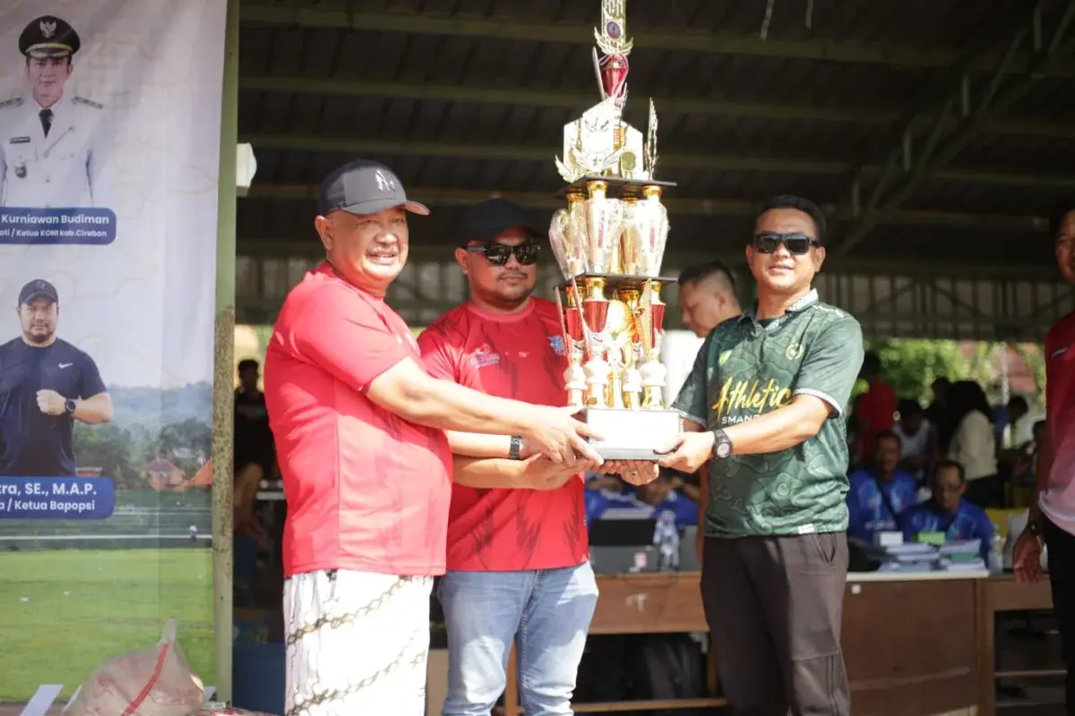 Sekda Kabupaten Cirebon Hendra Nirmala menyerahkan piala juara dalam kegitan Kejuaraan Invitasi Atletik Pelajar Tahun 2026 di Stadion Ranggajati Sumber, Kamis (16/4/2026)./* (Humas Pemkab Cirebon)